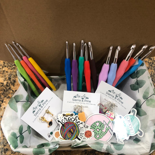 Set of colorful crochet hooks with packaging and branding on a brown surface